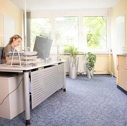 Eine Frau sitzt in einem hellen Büro